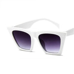 These sunglasses have a gloss white finish from the top part of the frame to the bottom, including the handle. The shape is square but stretched out towards the top. The lens is a purple gradient from a top to bottom tint, lighter at the bottom.