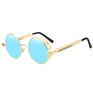 Stylish sunglasses with a blue lens and a gold rounded frame. The edges of the frames are extended by a small stylish bezel to cover the top and bottom of the eyes. With a spring attached across to the lower part of the handles.
