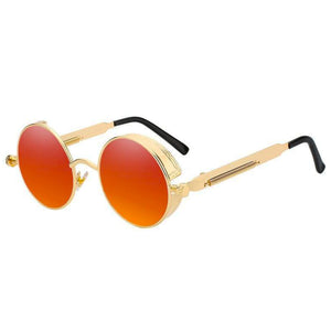 Stylish sunglasses with a crimson orange lens and a gold rounded frame. The edges of the frames are extended by a small stylish bezel to cover the top and bottom of the eyes. With a spring attached across to the lower part of the handles.
