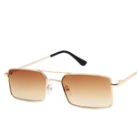 Sunglasses with a thin build and rectangle-shaped lens. The frame is gold and has a simple line connecting two parts at the top and in the middle of the lens. The colour of the lens is a light gradient fading from a dark brown to a shade of tea.
