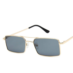 Sunglasses with a thin build and rectangle-shaped lens. The frame is gold and has a simple line connecting two parts at the top and in the middle of the lens. The colour of the lens is a light shade of grey.
