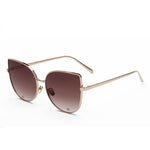 A pair of cat-eye styled sunglasses with a pointy corner at the top right and left with a circular design frame. A smooth round edge with a strong, sturdy gold finish around the lens. The lens is a shade of brown.