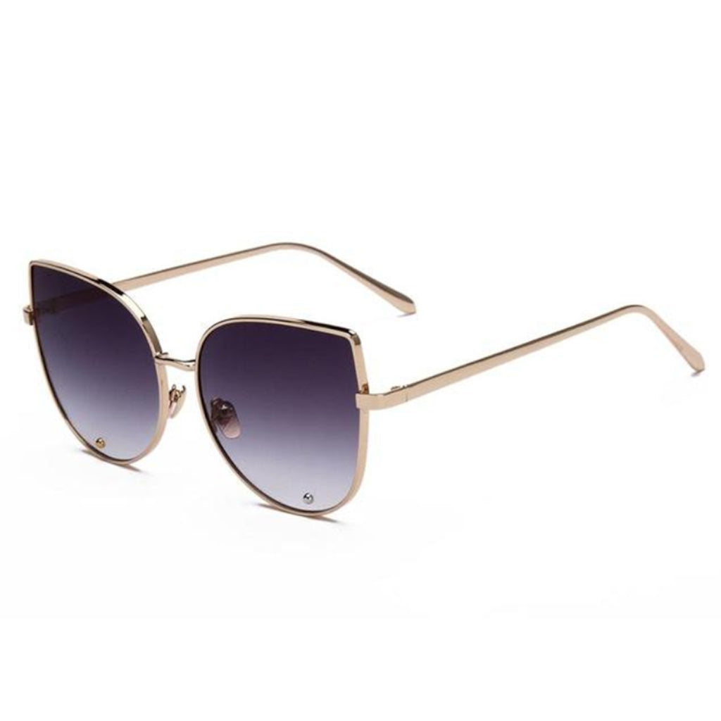 A pair of cat-eye styled sunglasses with a pointy corner at the top right and left with a circular design frame. A smooth round edge with a strong, sturdy gold finish around the lens. The lens is a shade of purple.