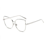 A pair of cat-eye styled glasses with a pointy corner at the top right and left with a circular design frame. A smooth round edge with a strong, sturdy silver finish around the lens. The lens is transparent.